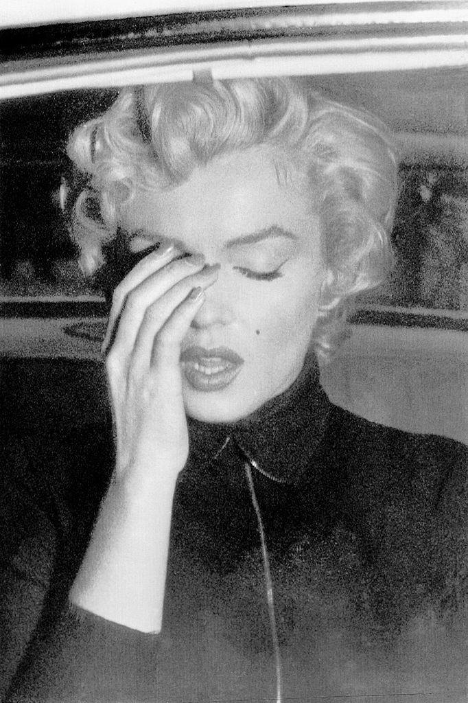 Marilyn Monroe se cubre el rostro con la mano