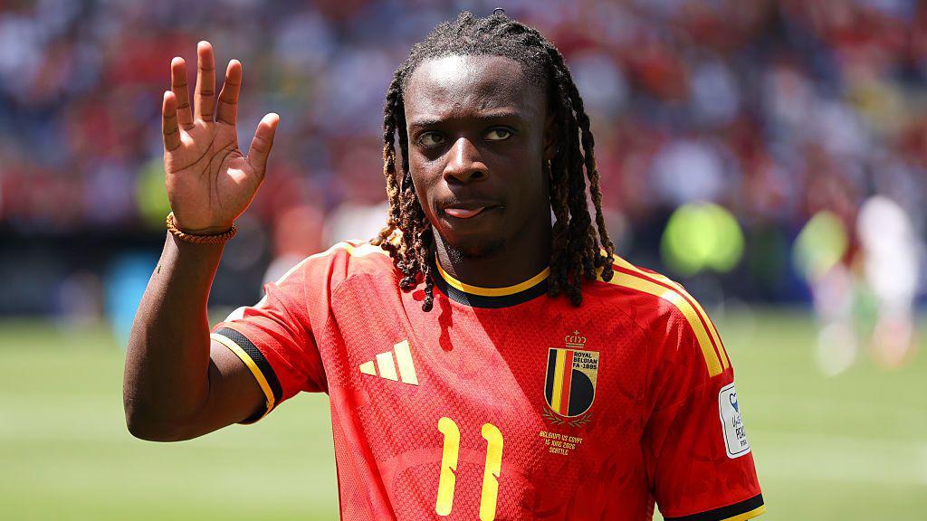 Jeremy Doku saluda a los seguidores vestido con la camiseta de B&eacute;lgica. 