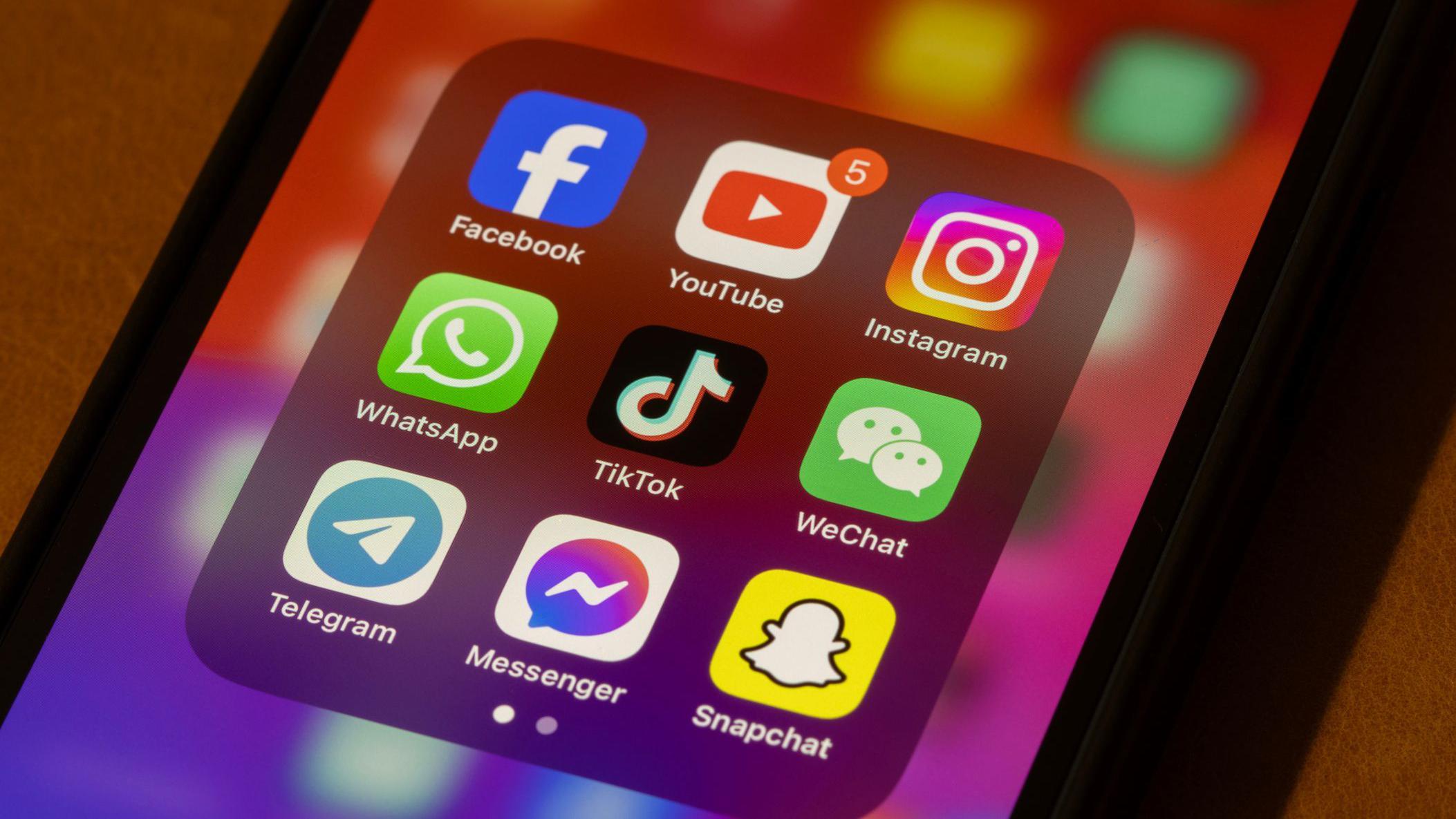 Un tel&eacute;fono que muestra los logos de las distintas redes sociales.
