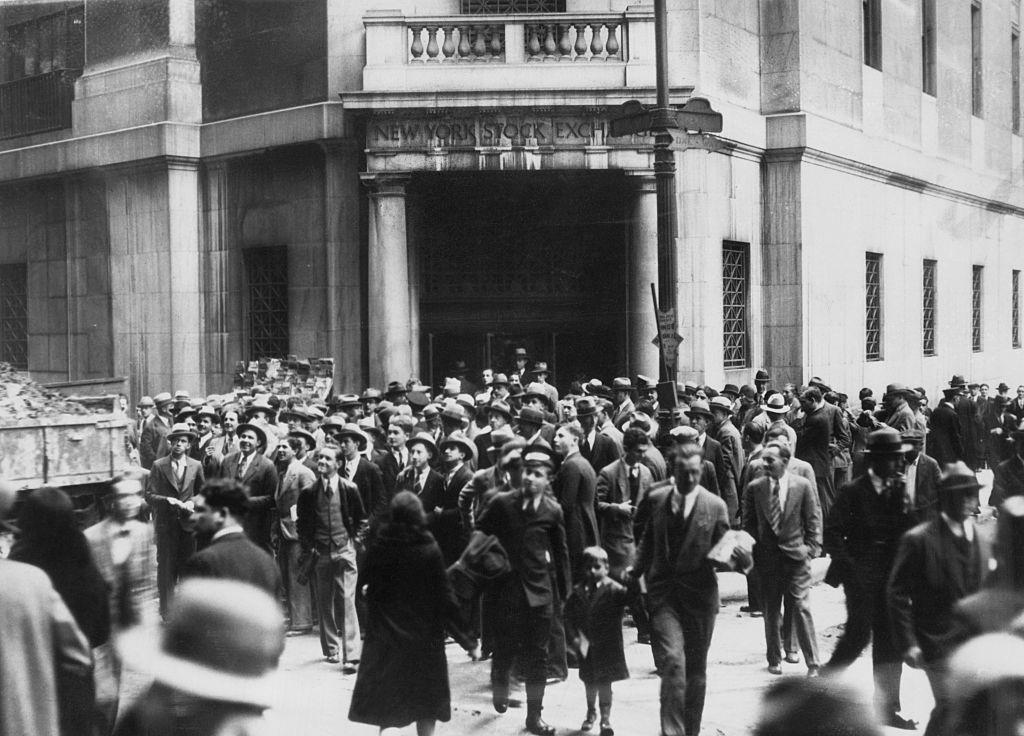 Muchas personas paradas frente a la bolsa de Nueva York, esperando noticias sobre su dinero.