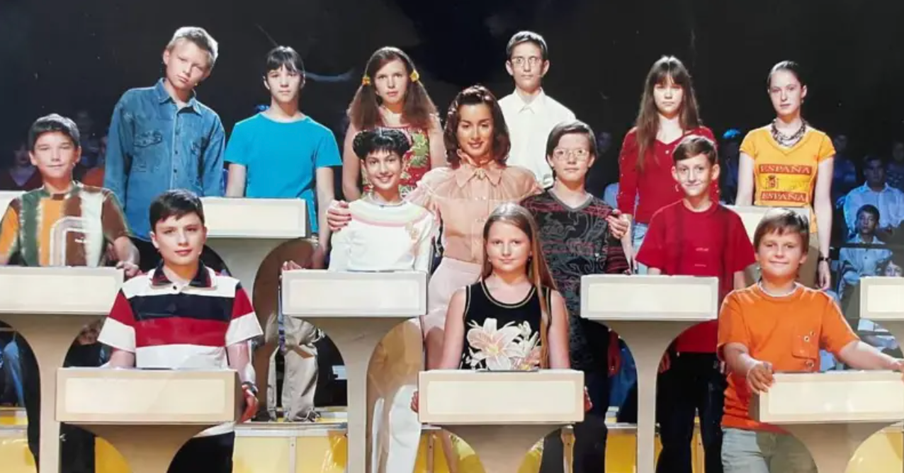 Con una camiseta roja, Oleksandr Ivanov es uno de los 13 ni&ntilde;os y ni&ntilde;as que est&aacute;n de pie, en tres filas, detr&aacute;s de atriles blancos, frente al p&uacute;blico de un estudio de televisi&oacute;n sentado en gradas. Una presentadora adulta, vestida con una blusa color melocot&oacute;n, est&aacute; de pie en el centro, abrazando a dos de los ni&ntilde;os.