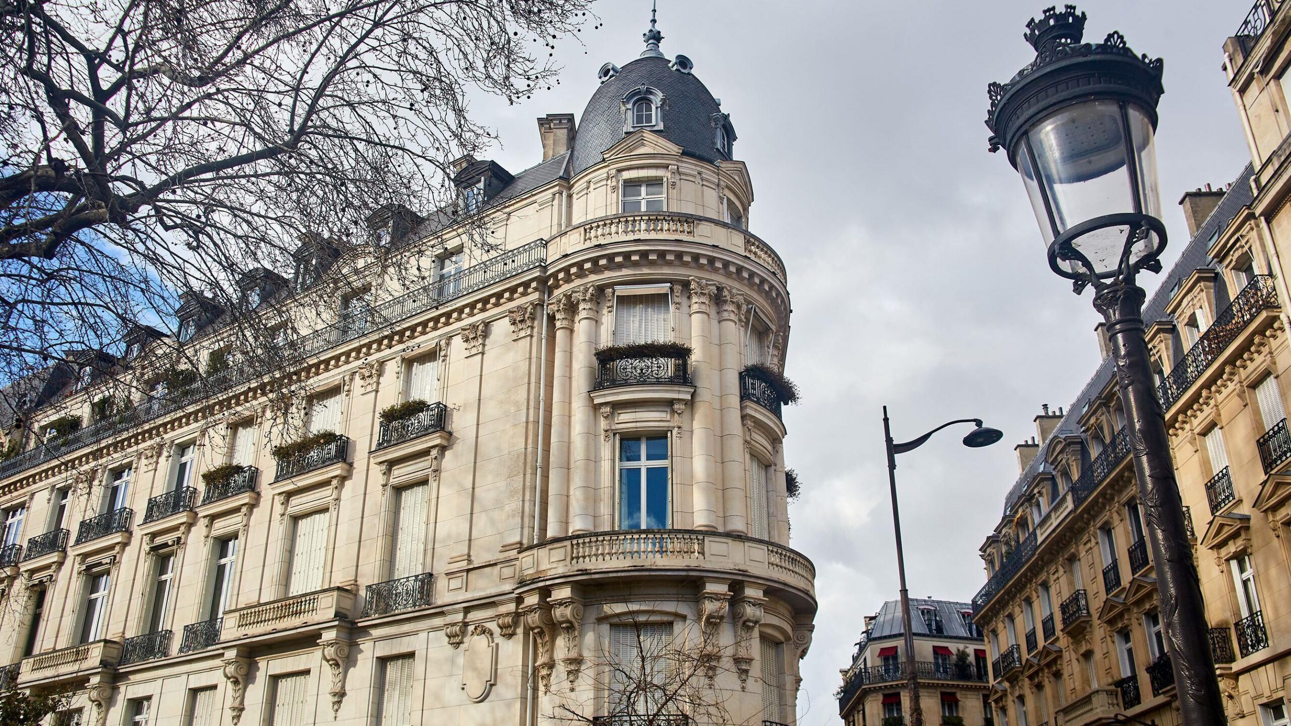 Vista exterior del edificio en la Avenida Foch donde se encontraba el apartamento de Epstein, que muestra un imponente edificio de piedra con una cúpula en la esquina.