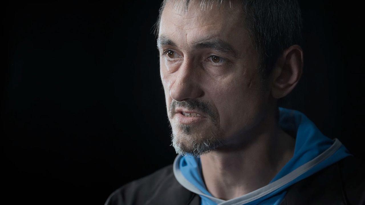 Retrato de Oleksii Sivak, quien lleva barba corta y bigote, mira hacia la izquierda de la c&aacute;mara y viste una sudadera con capucha azul claro debajo de una chaqueta negra.