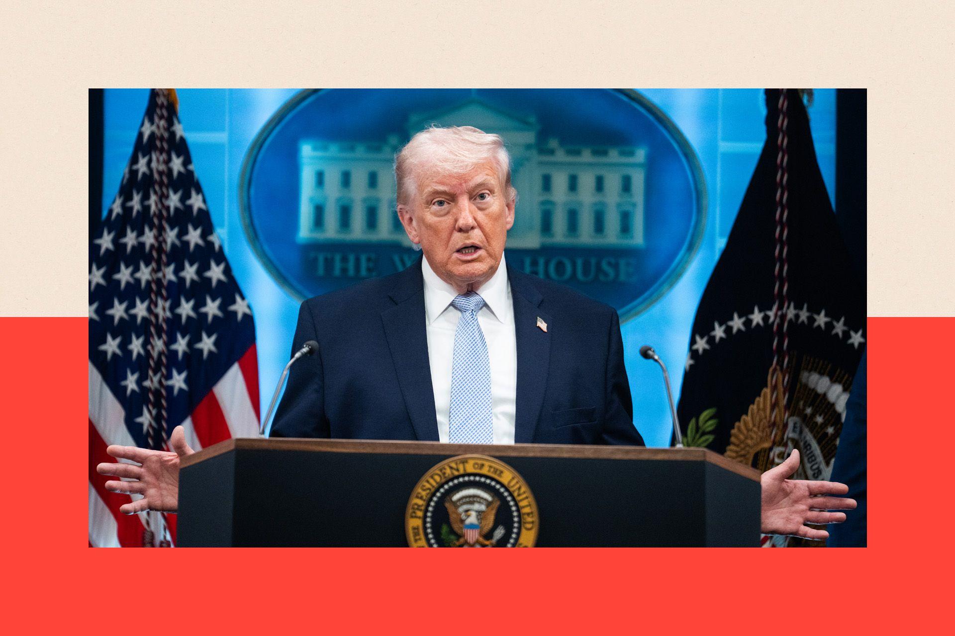 Donald Trump, vestido con un traje azul oscuro y una corbata azul claro, de pie detr&aacute;s de un podio.