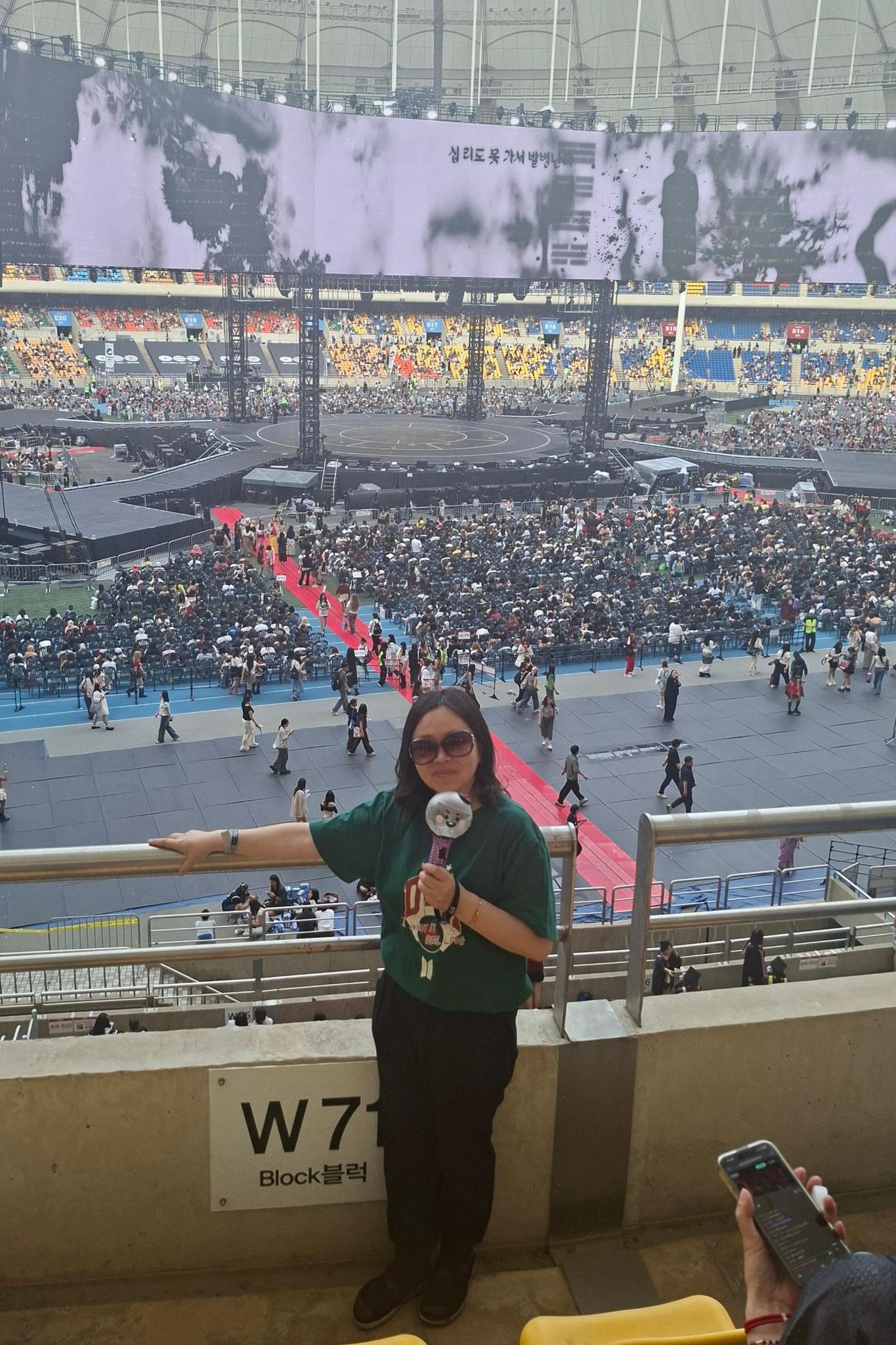 Yeon-su sostiene un "Army Bomb", el light stick oficial de BTS, durante el concierto de la gira mundial del grupo en Busan.