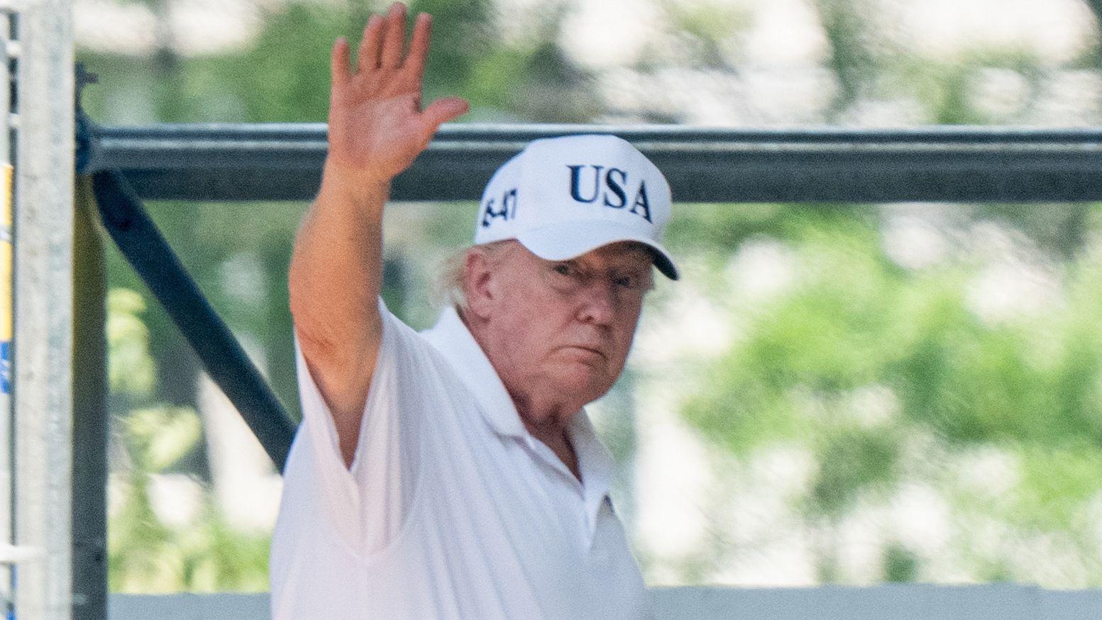 Trump saludando a la c&aacute;mara con una gorra de USA.