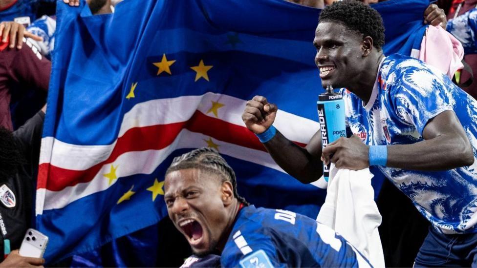 jugadores y aficionados con la bandera de Cabo Verde detr&aacute;s