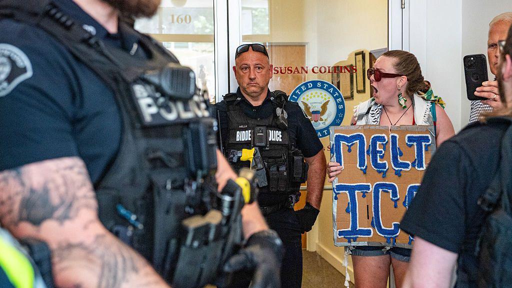 Manifestantes frente a la oficina de Susan Collins, junto a la polic&iacute;a.