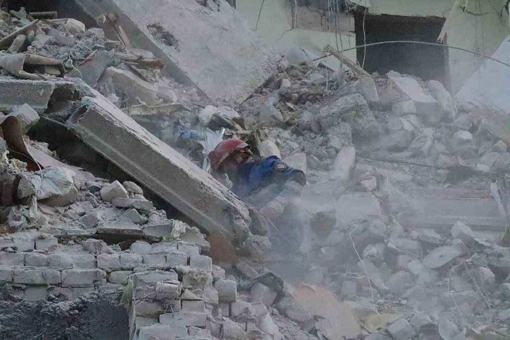 Un bombero entre los restos de un edificio.