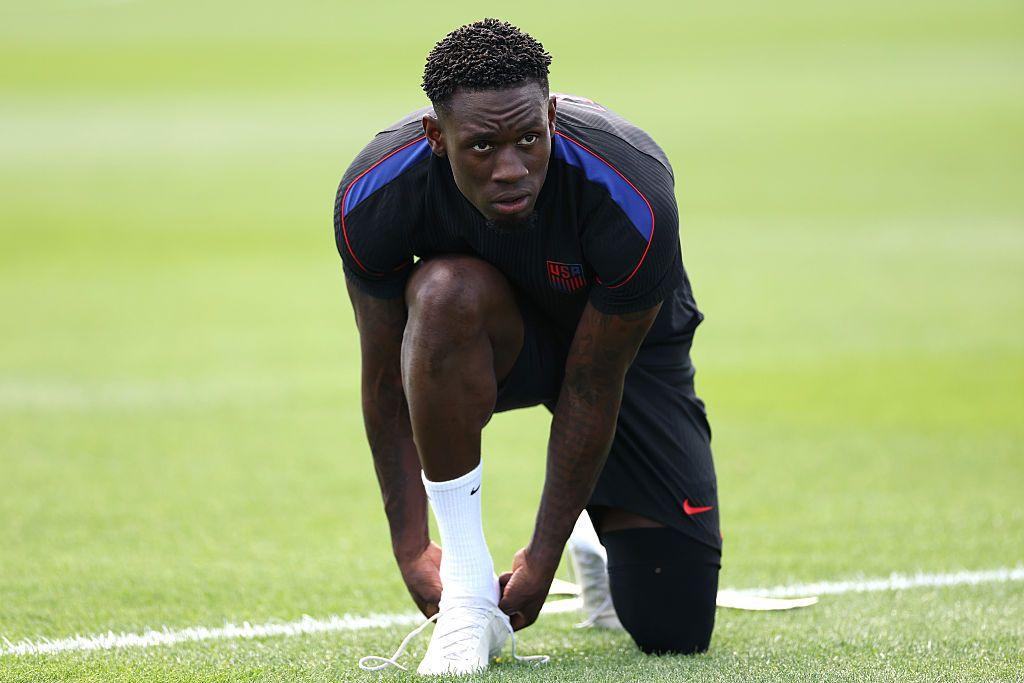 Falorin Balogun, arrodillado calz&aacute;ndose una bota en un entrenamiento de EE.UU. 