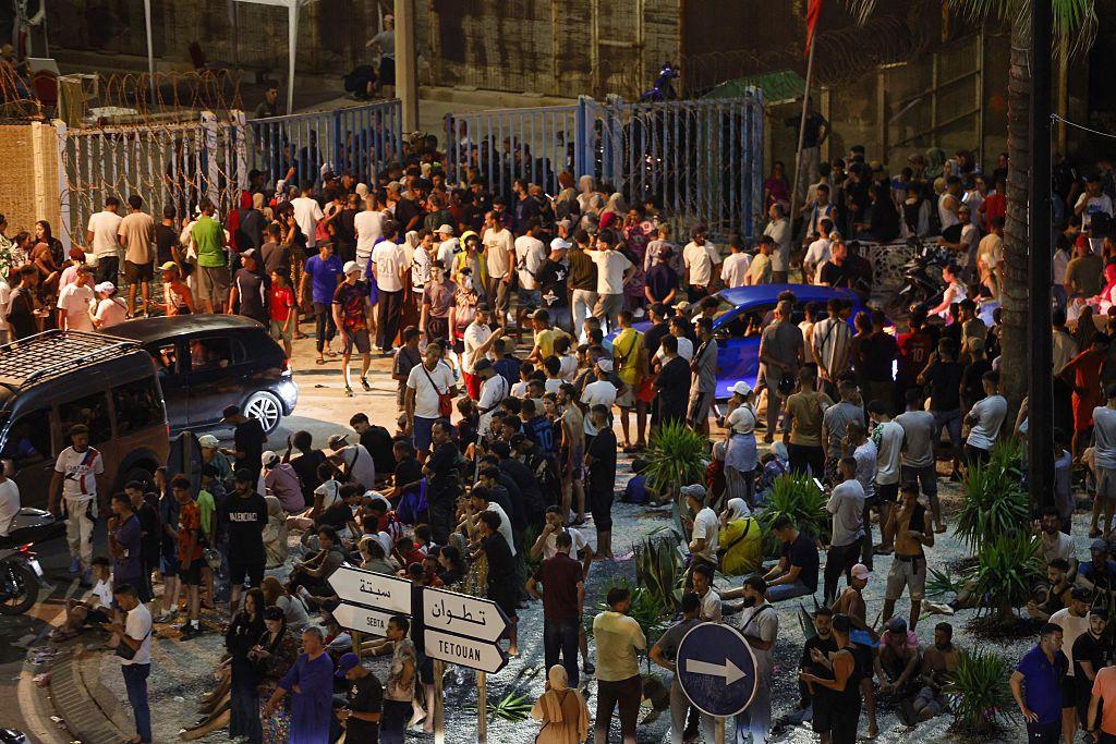 Una muktitud de personas se congrega ante la valla que separa territorio marroquí del español, noche del 30 al 31 de julio de 2026