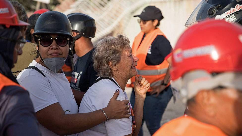 Una mujer llora mientras otra la abraza tras enterarse que uno de sus familiares no puedo ser rescatado con vida