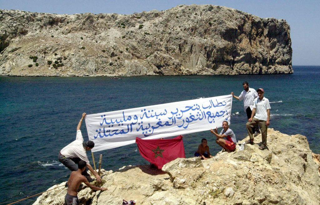 Manifestantes marroquíes ondean una pancarta que dice: "Exigimos la liberación de Ceuta y Melilla y de todos los territorios marroquíes ocupados", el 21 de julio de 2002, en la costa marroquí frente a la isla de Perejil.