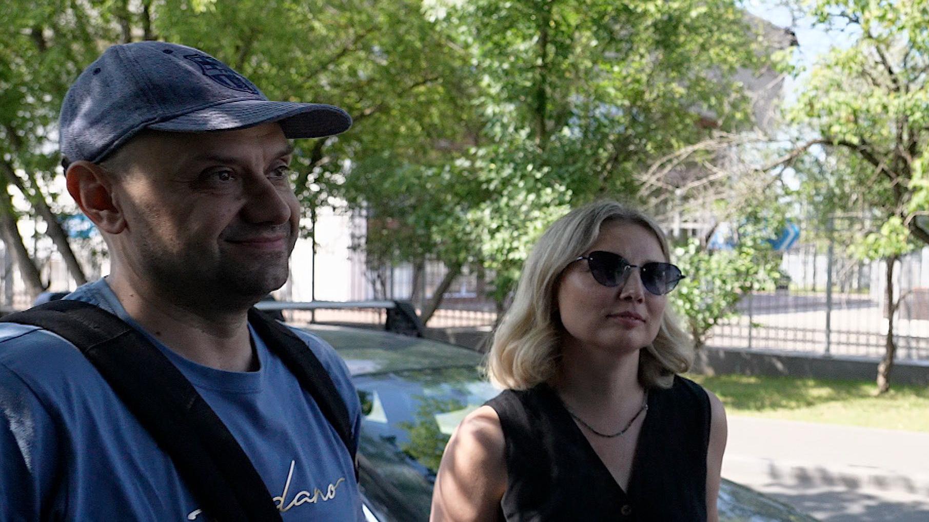En la fotograf&iacute;a se ve a Andrei y a su esposa Yekaterina hablando con la BBC, mientras que al fondo se aprecian autom&oacute;viles haciendo cola. 