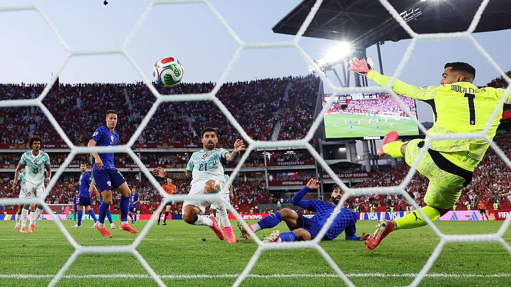 Jugadores de Croacia y Portugal observan mientras la pelota entra al arco portugu&eacute;s.