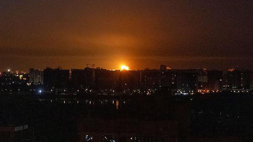 Una bola de fuego se ve entre edificios de Kyiv.