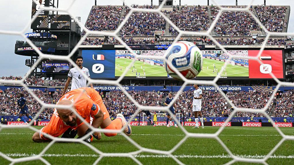El portero de Irak, Ahmed Basil, observa c&oacute;mo el disparo del delantero franc&eacute;s Kylian Mbapp&eacute; entra en la porter&iacute;a durante el partido de la fase de grupos del Mundial disputado en Filadelfia el 22 de junio de 2026.