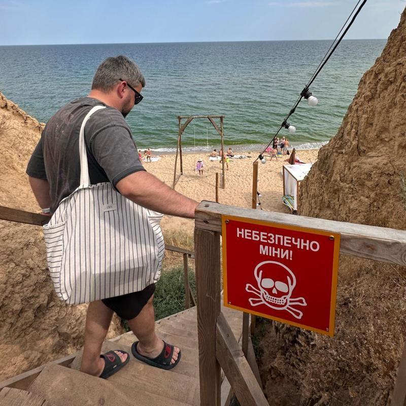 Una persona baja las escaleras para llegar a la playa. 
