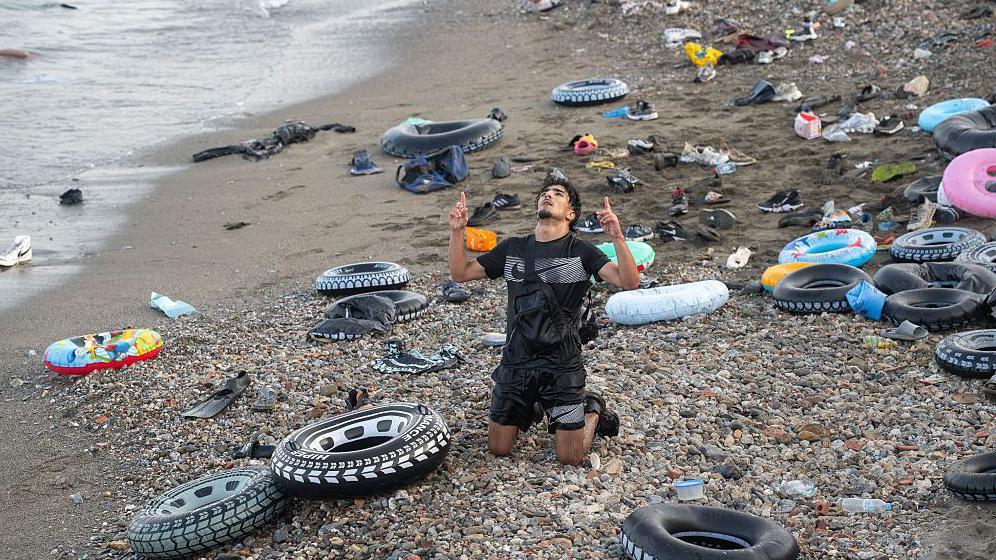 Migrantes y personas llegadas por vía marítima tras cruzar la frontera entre Marruecos y Ceuta, el 31 de julio de 2026, en Ceuta, España. En la imagen de ve un hombre arrodillado que parece estar agradeciéndole al cielo. 