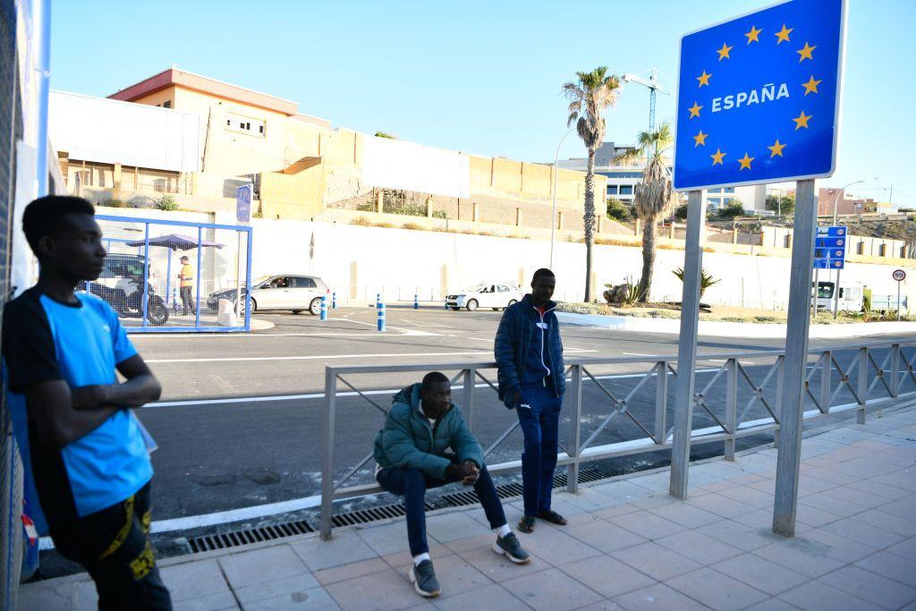 Tres personas cruzan la frontera entre Marruecos y España en Ceuta el 31 de mayo de 2022, día en que se abrieron las fronteras para los trabajadores transfronterizos marroquíes.