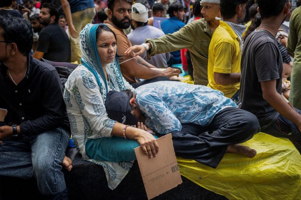 Krishna Arya, de 16 años, manifestante adolescente herido descansa en el regazo de su madre en Jantar Mantar, un día después de que miles de personas marcharan al parlamento por filtraciones de exámenes en Delhi