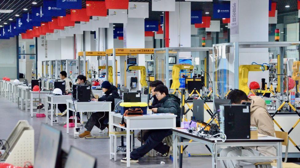 Estudiantes en un laboratorio de robótica lleno de elementos electrónicos y mecánicos. 