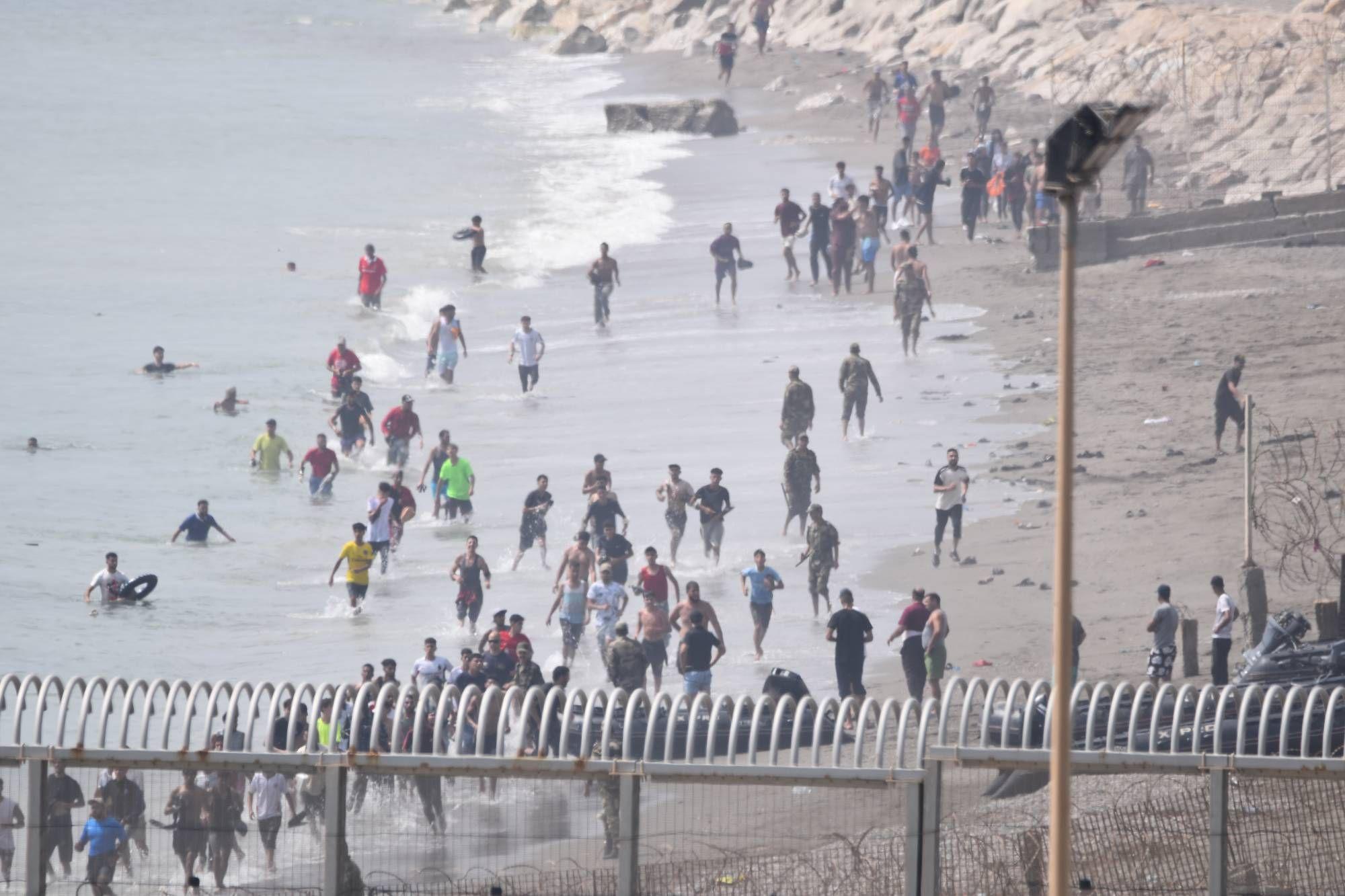 Varios migrantes intentan cruzar la frontera a nado el 30 de julio de 2026 en Ceuta.