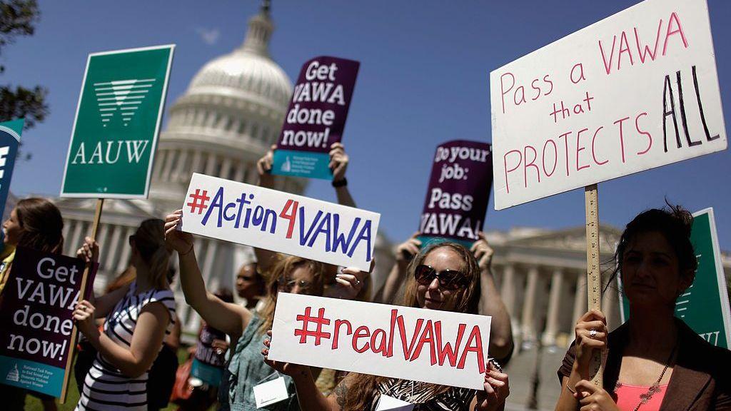 WASHINGTON, DC - 26 DE JUNIO: Miembros de la Organización Nacional de Mujeres (NOW), del Grupo de Trabajo Nacional para Poner Fin a la Agresión Sexual y la Violencia Doméstica Contra las Mujeres y otros grupos sostienen carteles en apoyo a la Ley de Violencia contra la Mujer (VAWA) con el Capitolio de fondo desenfocado, el 26 de junio de 2012 en Washington, DC. (Foto de Chip Somodevilla/Getty Images)
