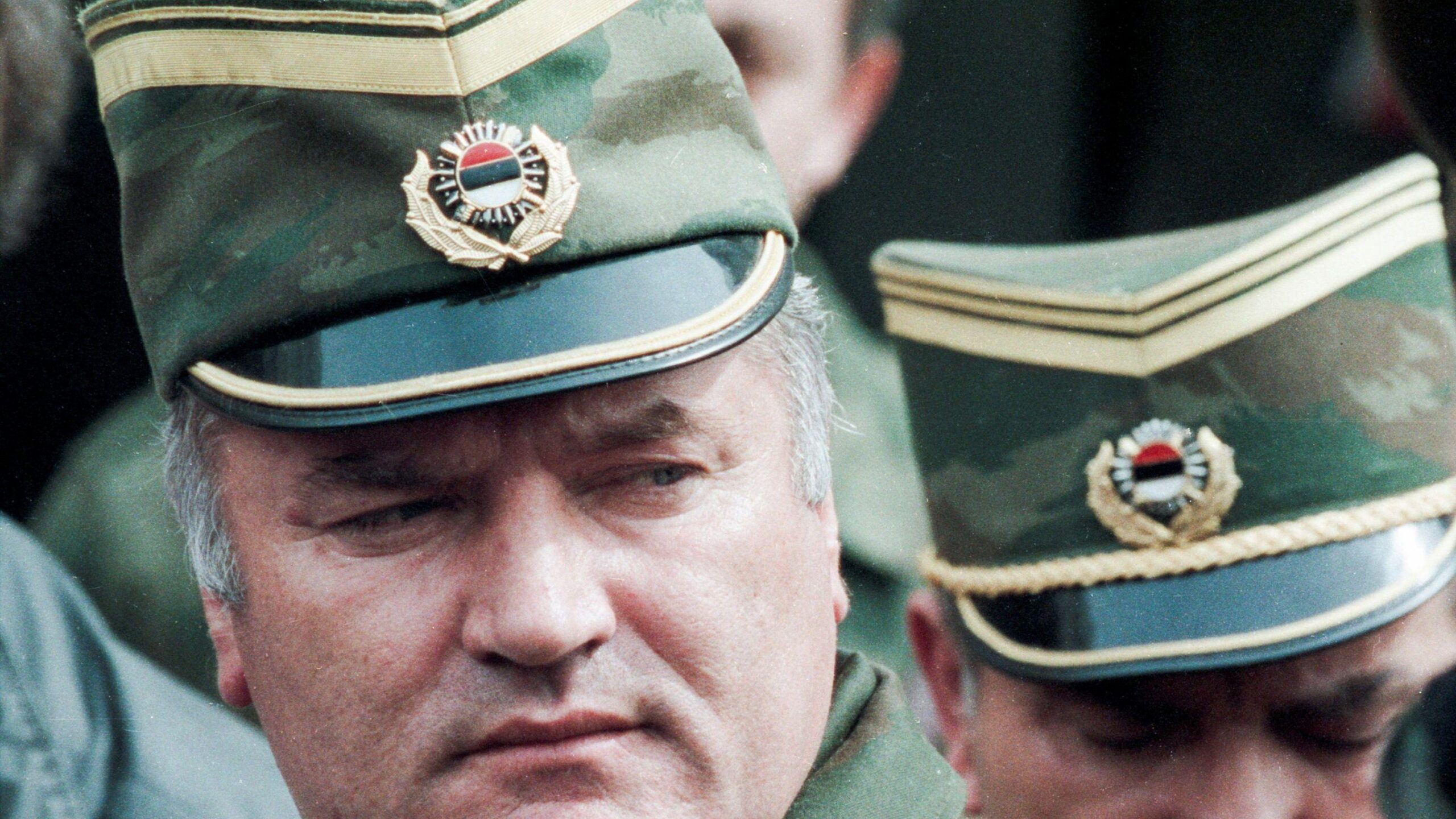 El general serbobosnio Ratko Mladić sale de una reunión en el aeropuerto de Sarajevo, Bosnia y Herzegovina, el 13 de abril de 1993. Lleva una gorra militar verde y dorada. 