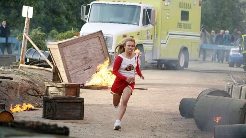 Una escena de la serie de TV Heroes muestra a Panettiere interpretando el  papel  Claire Benet, vestida de porrista y corriendo entre una zona de desastre con incendios y un vehículo de bomberos en el fondo