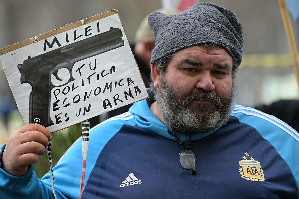 Hombre con un cartel con un dibujo de un revólver