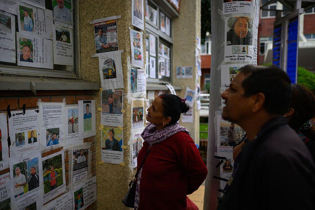 Familiares de desaparecidos buscando a sus parientes en las listas y carteles publicados en centros de refugio.