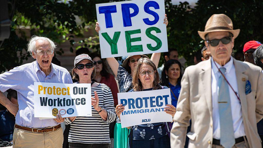 La gente sostiene carteles en una manifestación pidiendo al Congreso que restablezca el Estatus de Protección Temporal (TPS) para los haitianos, en Boston, Massachusetts, el 23 de julio de 2026. (Foto de JOSEPH PREZIOSO / AFP vía Getty Images)