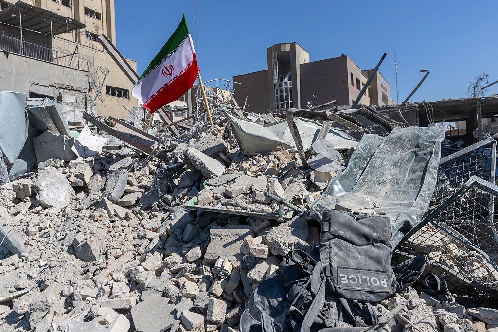 Una bandera iraní ondea entre los escombros de una comisaría de policía, dañada en los ataques aéreos de ayer, el 3 de marzo de 2026 en Teherán.
