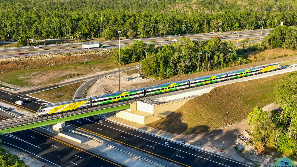 Un tren Brightline cruza por un puente sobre una carretera de Florida. 