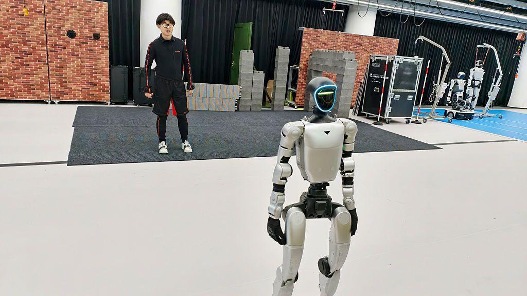Una persona entrenando a un androide en las instalaciones de Unitree