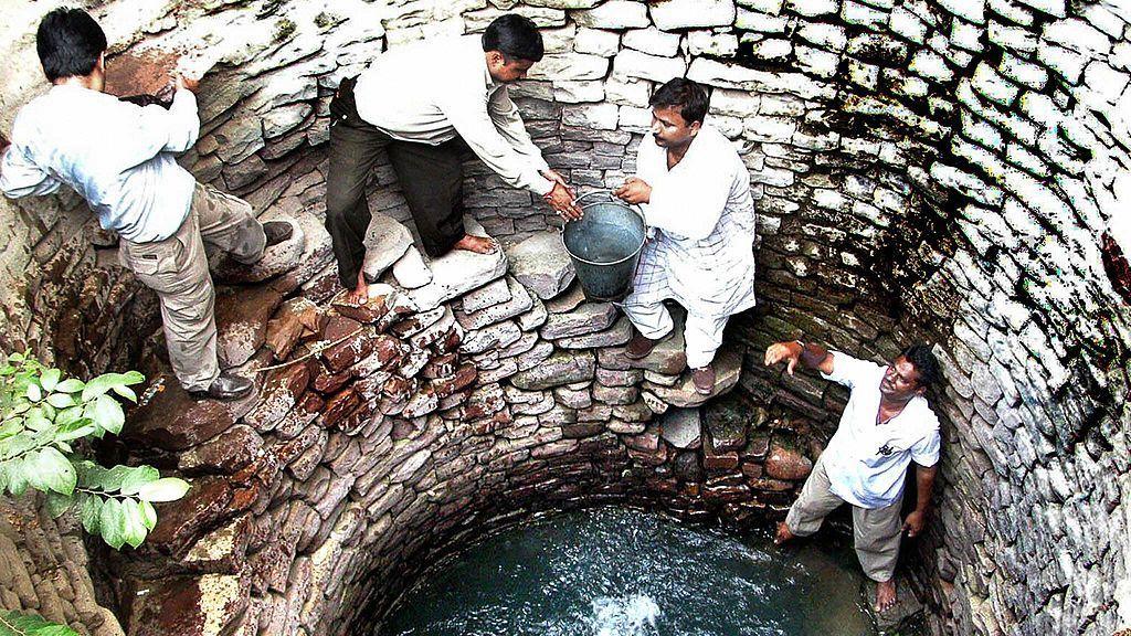 Un grupo de hombres sacan agua de un pozo construido hace 150 años en la región de Bhopal.