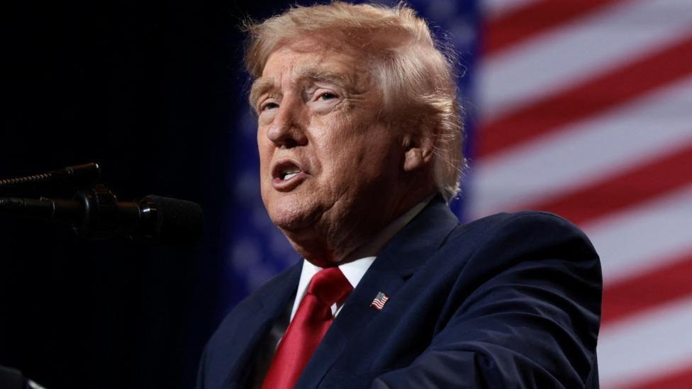 Presidente Donald Trump con traje oscuro y corbata roja