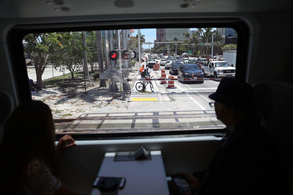 Autos detenidos en un paso a nivel de una calle de Fort Lauderdale, vistos desde la ventana de un tren Brightline. 