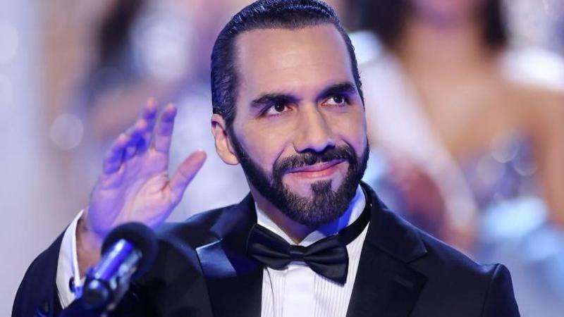 Nayib Bukele saluda con la mano vestido con traje de gala.