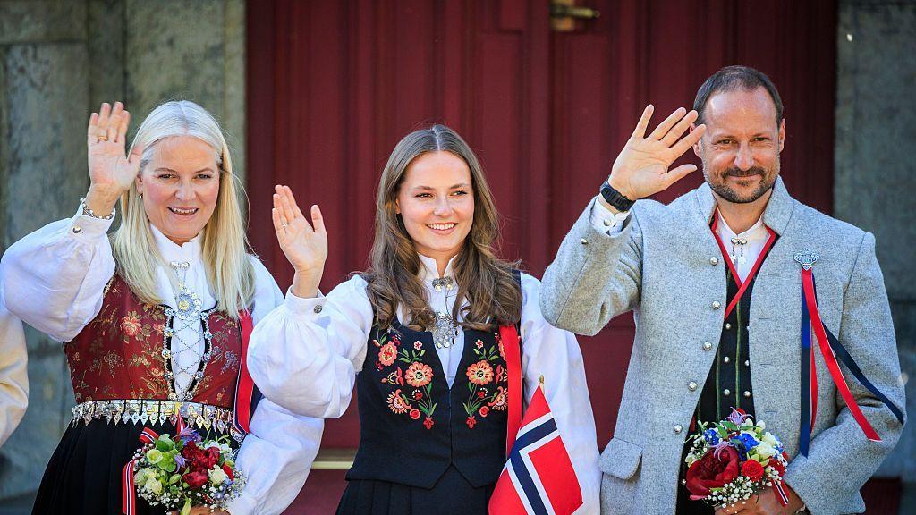 La entonces princesa heredera Mette-Marit (izquierda), su hija la princesa Ingrid y el entonces príncipe heredero Haakon saludando a la multitud en 2025.