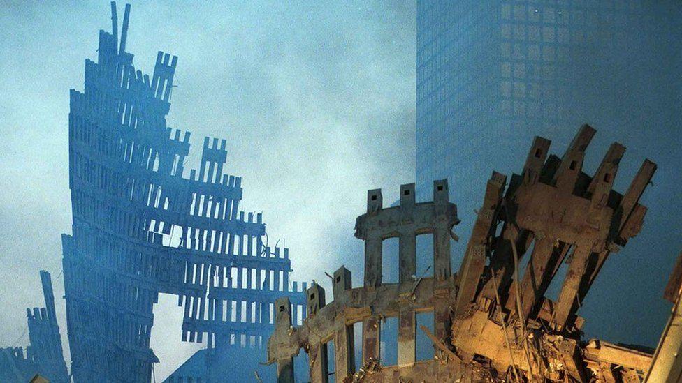 Una fotografía que muestra los restos destrozados de las torres gemelas, dos días después del ataque. El aire aún está lleno de humo.