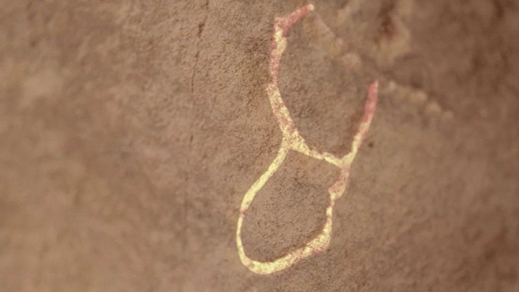 Una inscripción en una pared, en forma de la cabeza de un buey simplificada. 