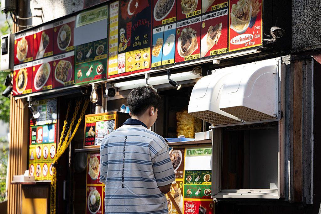 Un hombre pide un kebab en un local del distrito de Okubo en Tokio, conocido por sus comunidades de inmigrantes, incluidos residentes de Corea del Sur, el sudeste asiático y el sur de Asia.