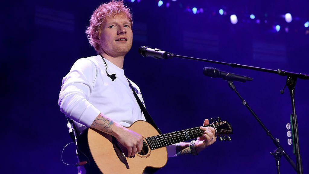 Ed Sheeran toca la guitarra en un concierto