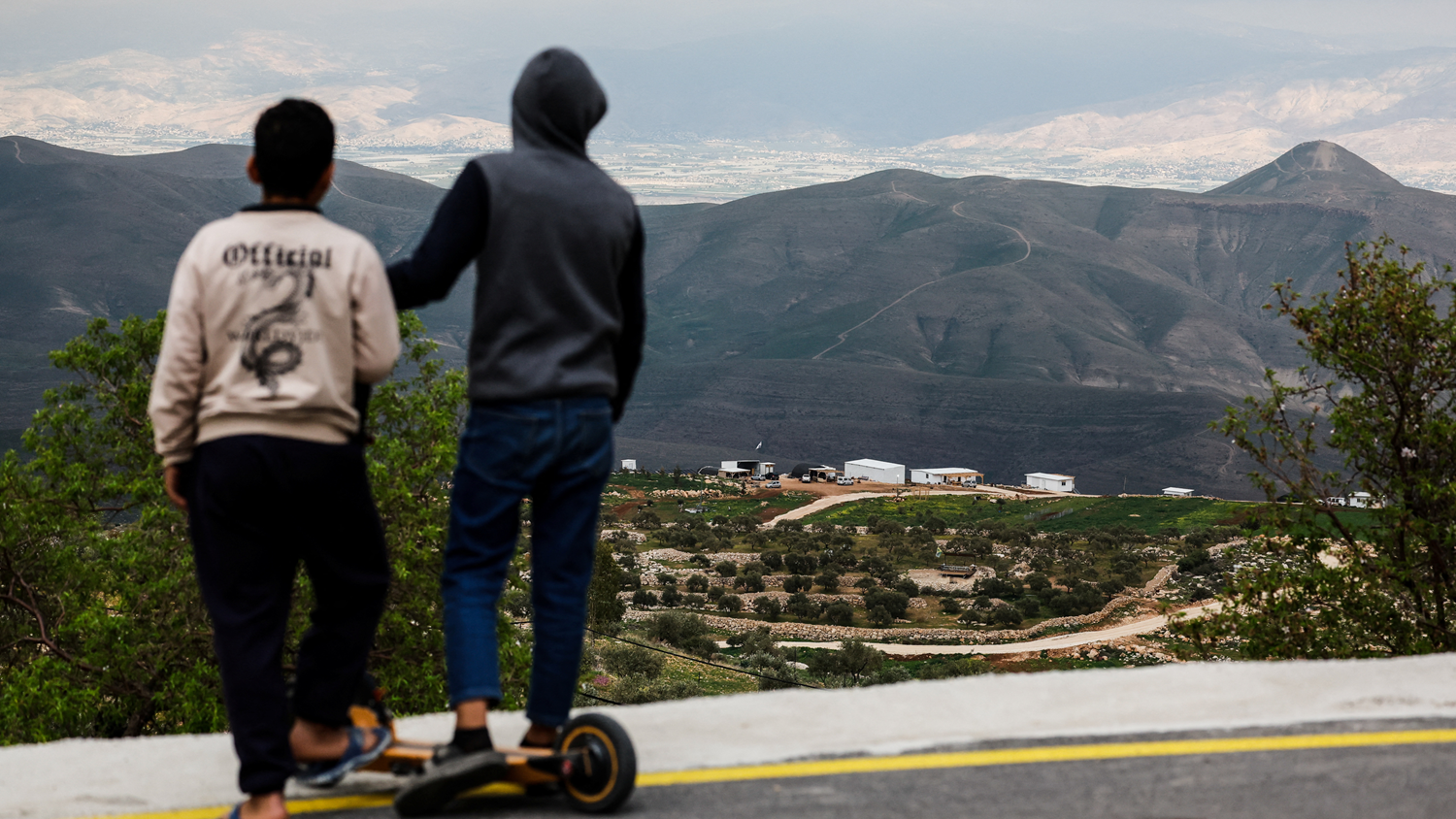Jóvenes palestinos observando un nuevo asentamiento israelí desde la aldea palestina de Duma, cerca de Nablus, en la Cisjordania ocupada por Israel.