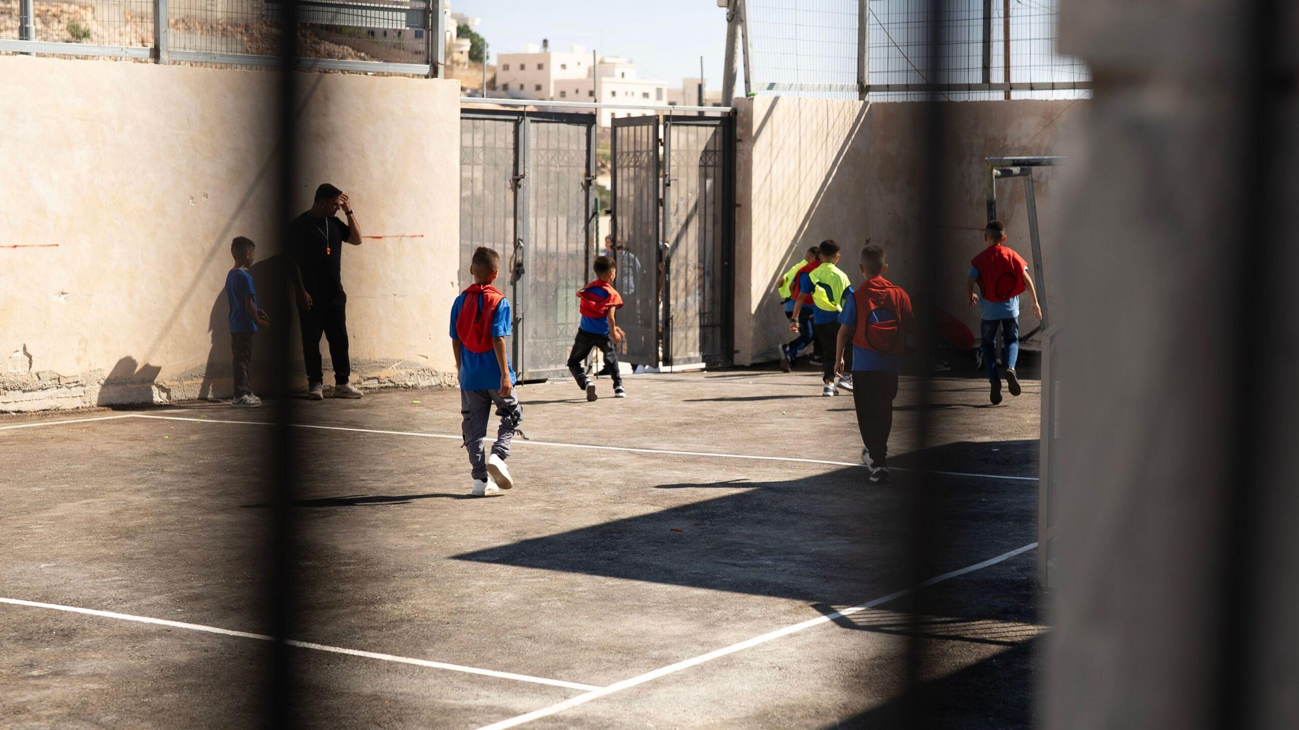Los niños juegan al fútbol en el parque infantil. 