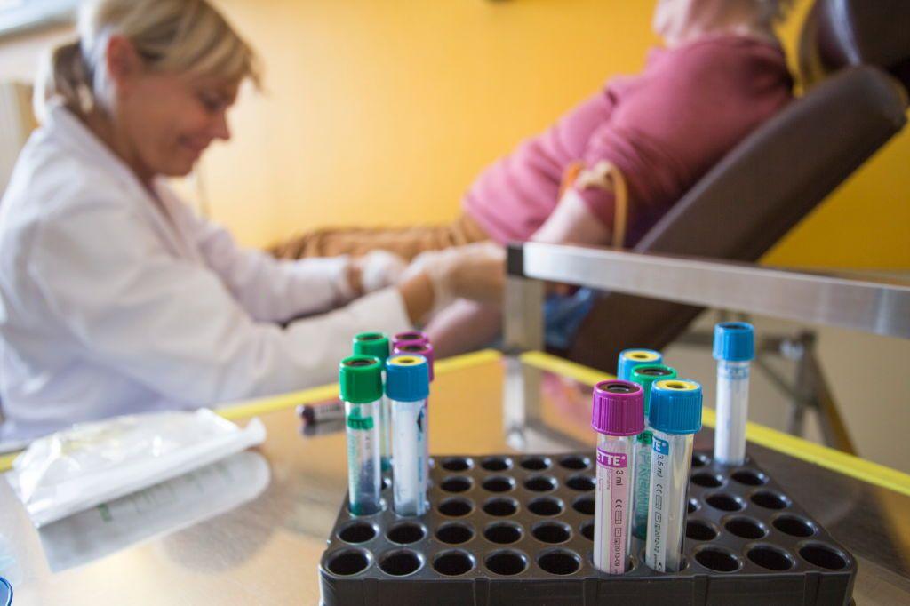 Una enfermera extrae sangre de una pacienta oncológica en Francia.