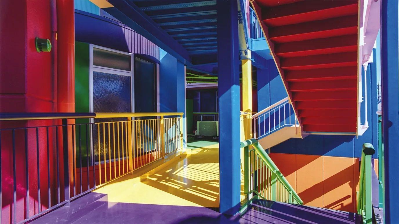 El corredor de un edificio pintado de una inmensa gama de colores.