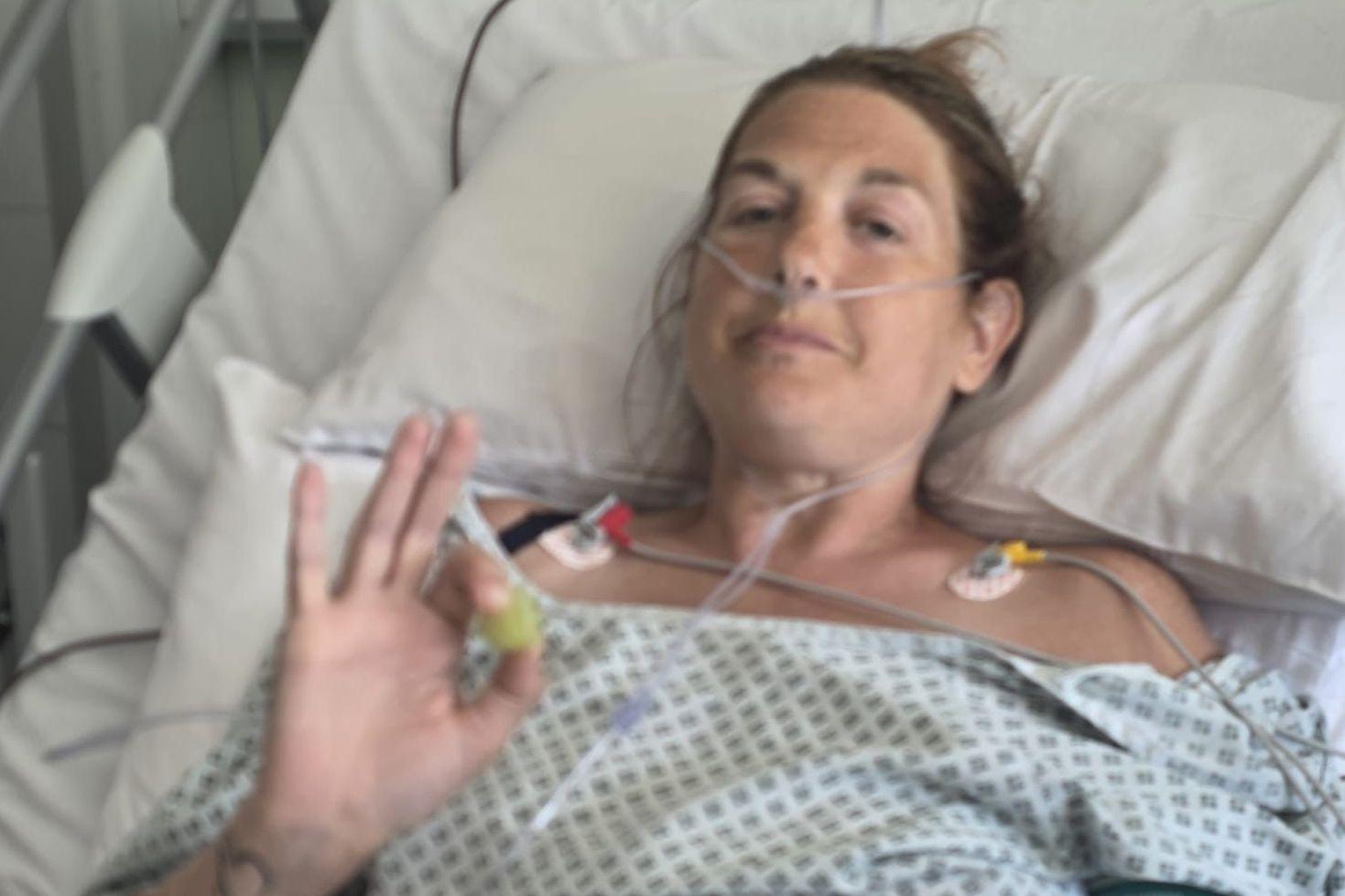 En la fotografía, Karen aparece con una bata de hospital, acostada en una cama de hospital con tubos conectados a su nariz y otros equipos de monitorización. 